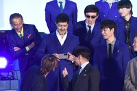 フォトセッションのスタンバイ中、渋谷龍太と西川貴教をカメラに収める谷中敦。