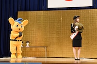 最新のヘルメット事情を学ぶ本田仁美（AKB48 / 右）とピーポくん（左）。