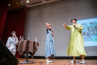 古町の通りを体で表現しようとするNao☆（中央）とMegu（右）。