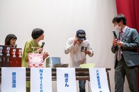 老眼でクジの番号がわからない熊さん（右から2番目）。