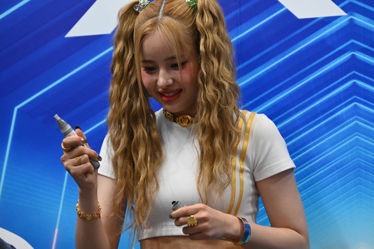 サインを書くためにペンの蓋を外すHARVEY。 - XG「KCON」ブース
