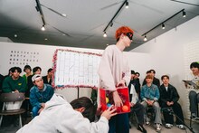 くじを引くユーキ（超特急）。ボックスを支えるのはアロハ（超特急）。