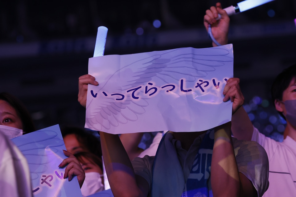 「いってらっしゃい」と書かれた紙を掲げる乃木坂46ファン。（提供：ソニー・ミュージックレーベルズ）