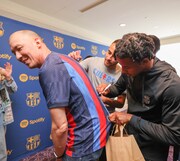 Spotifyの日本法人新代表取締役のトニー・エリソン氏にサインするFCバルセロナの選手たち。