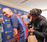 Spotifyの日本法人新代表取締役のトニー・エリソン氏にサインするFCバルセロナの選手たち。