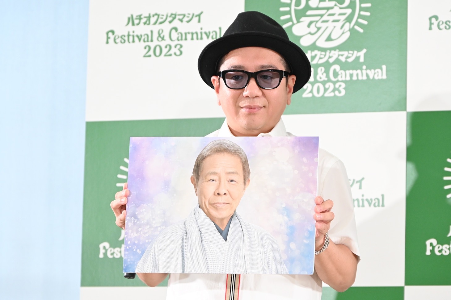 北島三郎のパネルを持つLITTLE（KICK THE CAN CREW）。