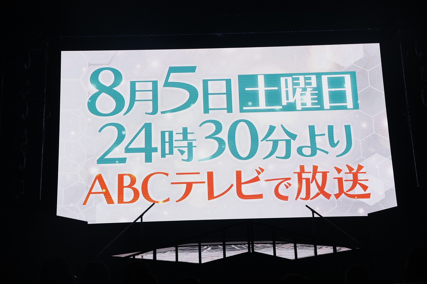 「ノイミーステーションTV」放送決定の知らせが映し出される会場のスクリーン。(c)YOANI