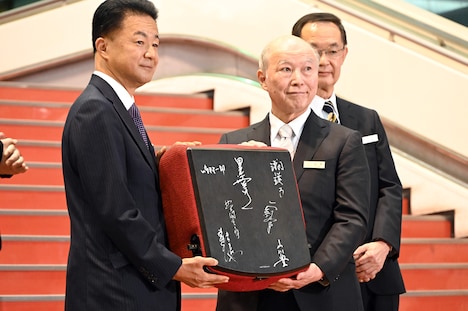 中野サンプラザの金野晃代表取締役会長（右）から野村不動産の松尾大作代表取締役社長（左）に贈呈されたサイン入りの中野サンプラザの椅子。