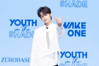 指ハートを作るキム・ギュビン。 (c)WAKEONE