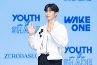 両手を振るソン・ハンビン。 (c)WAKEONE