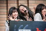 フォトセッション中の菅田愛貴（超ときめき♡宣伝部）と下尾みう（AKB48）を睨む幽霊。