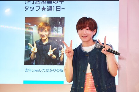 居酒屋バイト時代の写真のポーズを真似る春斗。（撮影：上溝恭香）