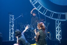 立ち上がってネギライトを振り回す岡本啓佑（Dr）。