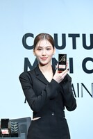 サイン入りの「クチュール ミニ クラッチ」を持つSANA（TWICE）。