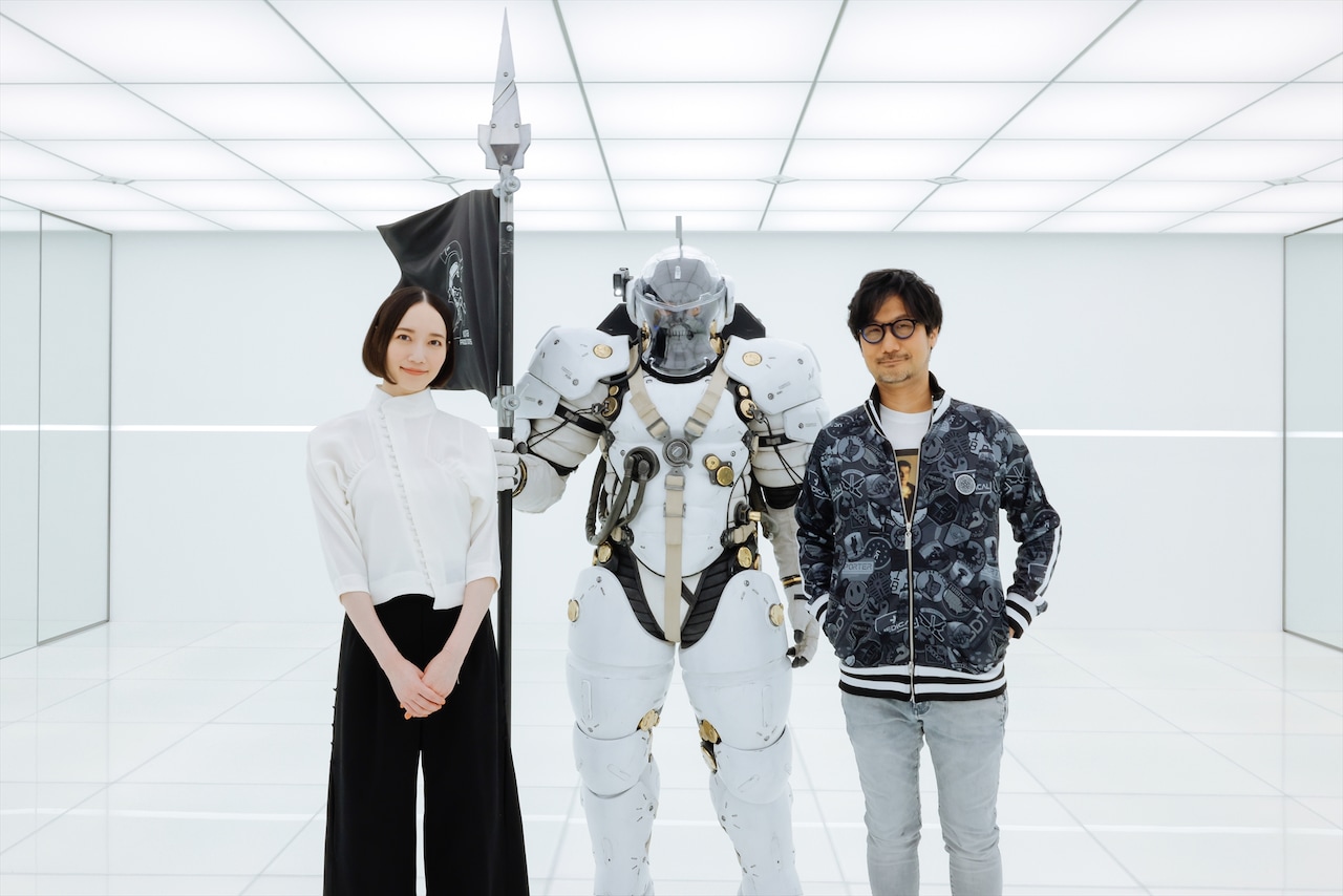 エントランスで記念撮影をする、のっちさん、ルーデンス、小島秀夫さん。