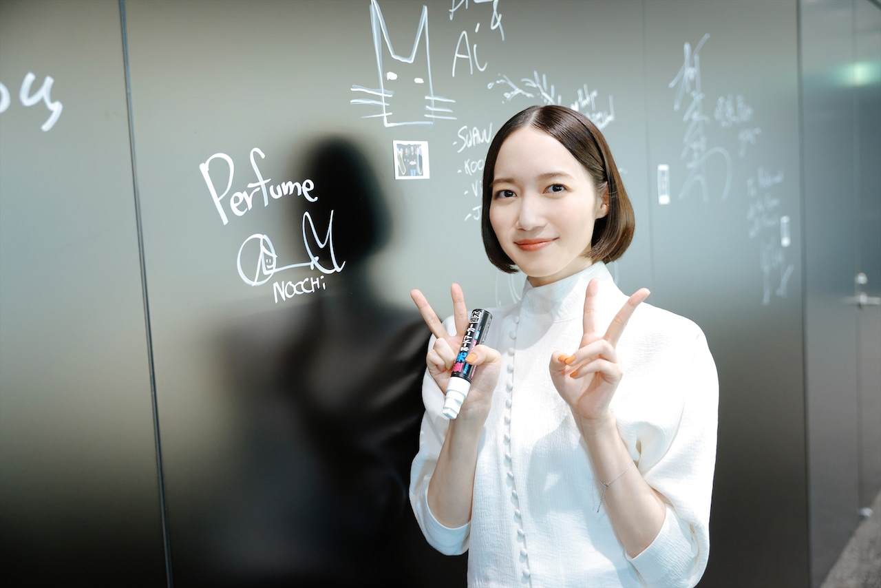 サインを書いてカメラにピース。