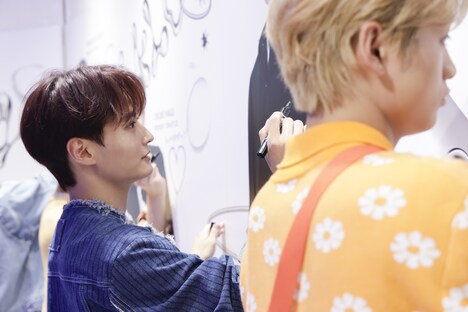 真剣な表情でサインを書く寺尾香信。