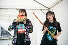 スイカを頬張ろうとする小久保柚乃（左）と木刀を構える桜木心菜（右）。