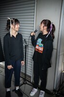 雨でずぶ濡れのエビ中ファミリーを軽妙なトークで楽しませる真山りか（右）とニコニコする仲村悠菜（左）。