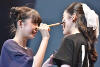 真剣な顔で風見和香（右）の頬に落書きをする小久保柚乃（左）。