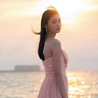 桜色ドレス着た遠藤さくら、夕暮れの海辺で佇む