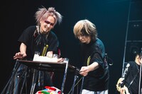 ケーキを運び込む柩（G / NIGHTMARE）、ミヤ（G / MUCC）。（撮影：冨田味我）