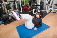 お腹を丸め、息を吐き切りながら膝を曲げます。腹筋への負荷を実感し、ナルハワールドさんは苦悶の表情。