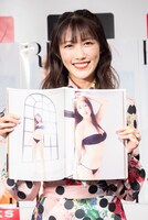 写真集のお気に入りカット（ページ右側）を見せる高城れに。