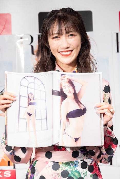 写真集のお気に入りカット(ページ右側)を見せる高城れに。