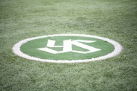 人工芝に東京ヤクルトスワローズの球団マークが刻まれた明治神宮野球場のネクストバッターズサークル。