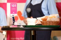 左からモーニング娘。'23。オリジナル番号札、コーヒー、てりやきバーガーのオニポテセット。