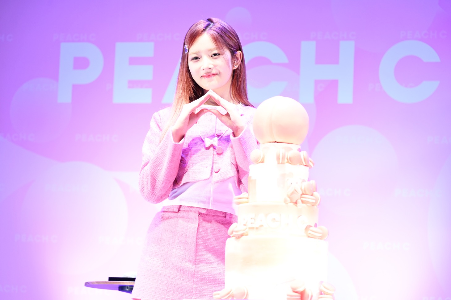「PEACH C」のポーズを決めるレイ。