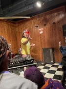 DJプレイ中、オーディエンスにハムをふるまう掟さん。