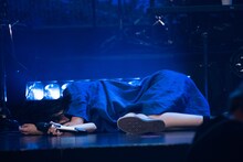 横たわりながら歌唱するアイナ・ジ・エンド。