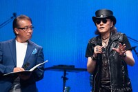 しゃべり続ける石井竜也（右）を止めようとタイミングを見計らう司会の赤坂泰彦（左）。