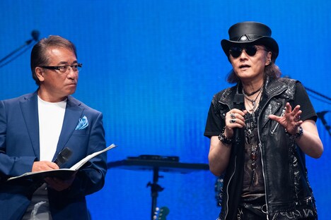 しゃべり続ける石井竜也（右）を止めようとタイミングを見計らう司会の赤坂泰彦（左）。