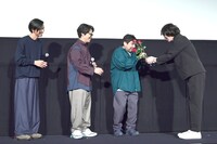 メンバーに花を贈る佐渡岳利監督（右）。