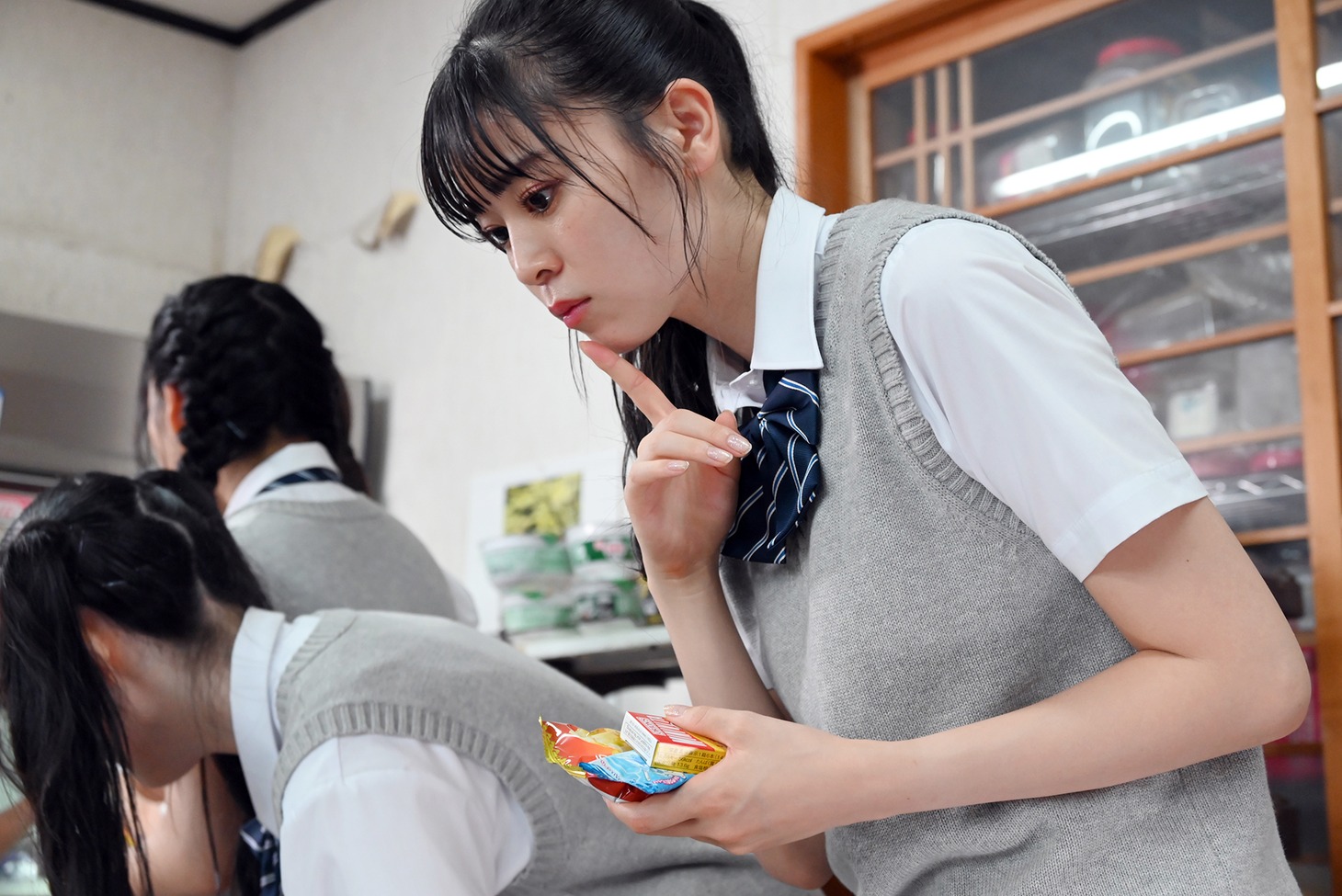 どの駄菓子を買うか悩む坂井仁香。