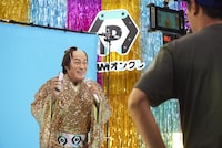 「DMMオンクレ」のテレビCM「毎日がカルナバル」編の撮影メイキングカット。