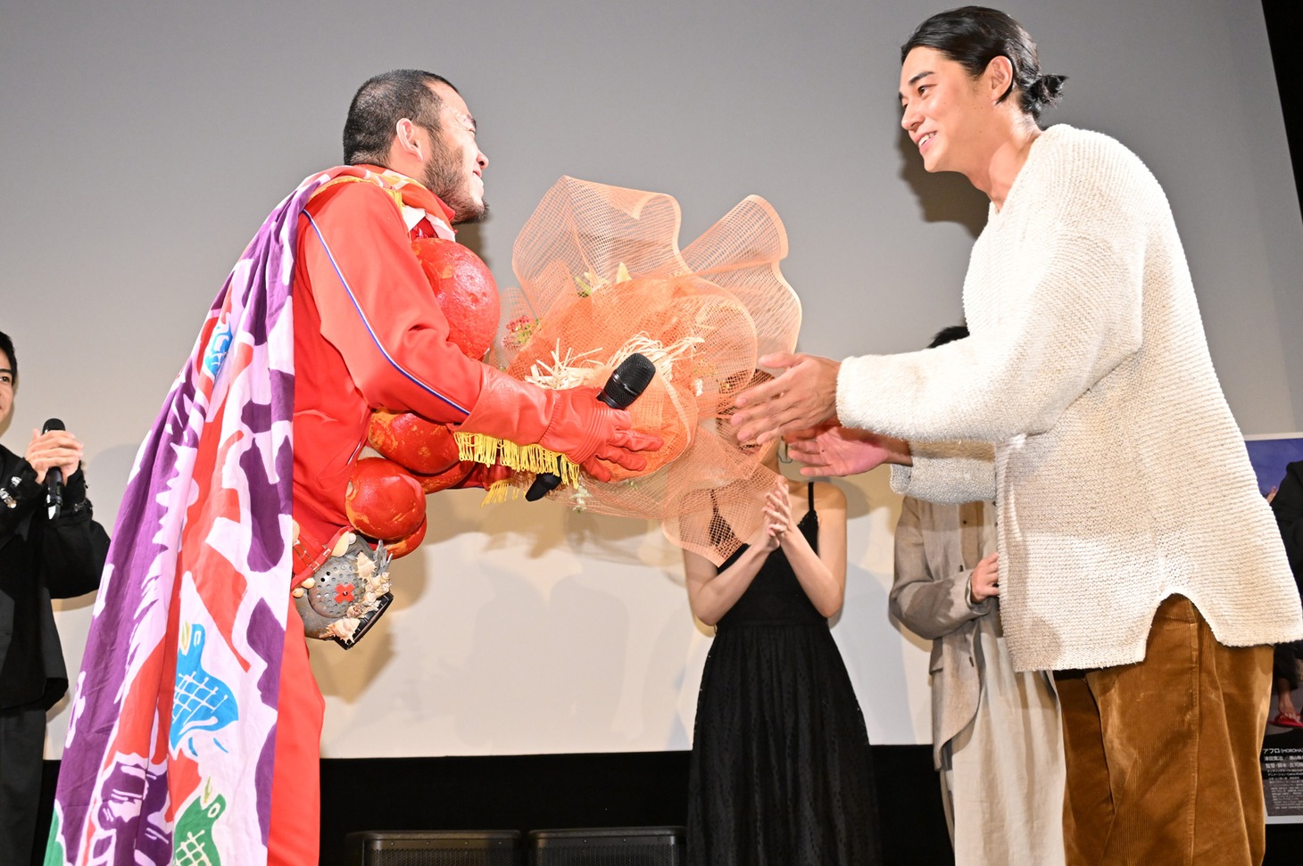 アフロに花束を手渡す東出昌大。