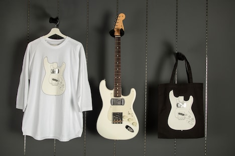 左からオリジナルTシャツ、シグネチャーギター、オリジナルトートバッグ。