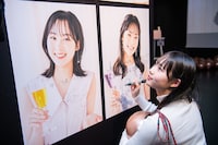 ポスターにサインと落書きを入れる入江里咲。