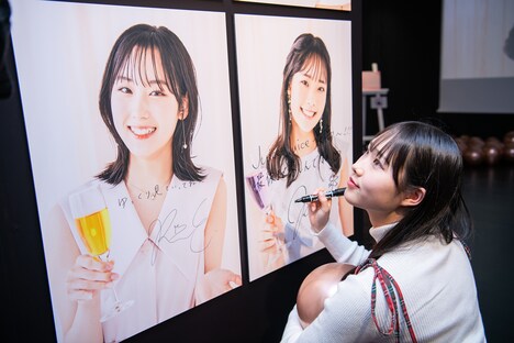 ポスターにサインと落書きを入れる入江里咲。