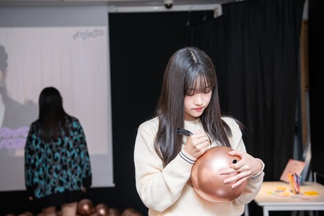 風船に絵を描く遠藤彩加里。