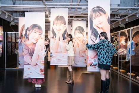 タペストリーに抱きつく入江里咲、遠藤彩加里、石山咲良（左から）。