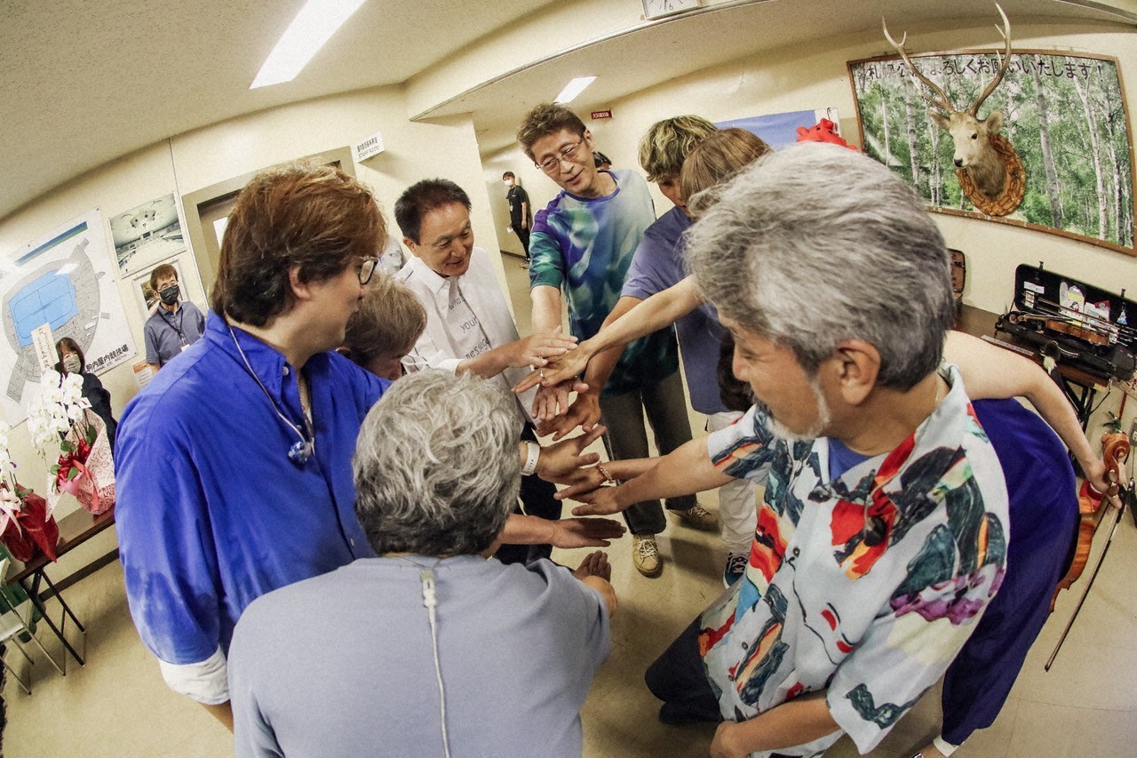人気画像3位は「小田和正の75歳アリーナツアーにNHKが密着」より、ライブ会場で円陣を組む小田和正（中央）。（写真提供：NHK）