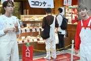 チームメンバーに無断で惣菜店に並ぶマサヒロ（中央）。