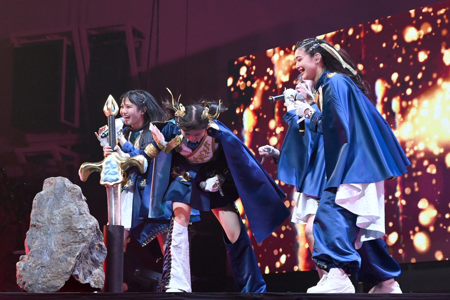 剣を抜くためにヘッドバンギングする藤谷美海（中央）。