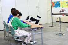 体を張ってカモノハシの魅力を伝えるタカシ先生（奥）。