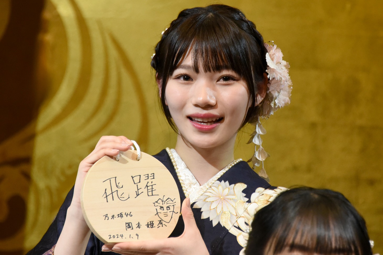 絵馬を記者陣に見せる岡本姫奈。
